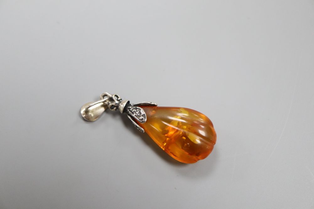 A silver and amber pendant with inclusions,
